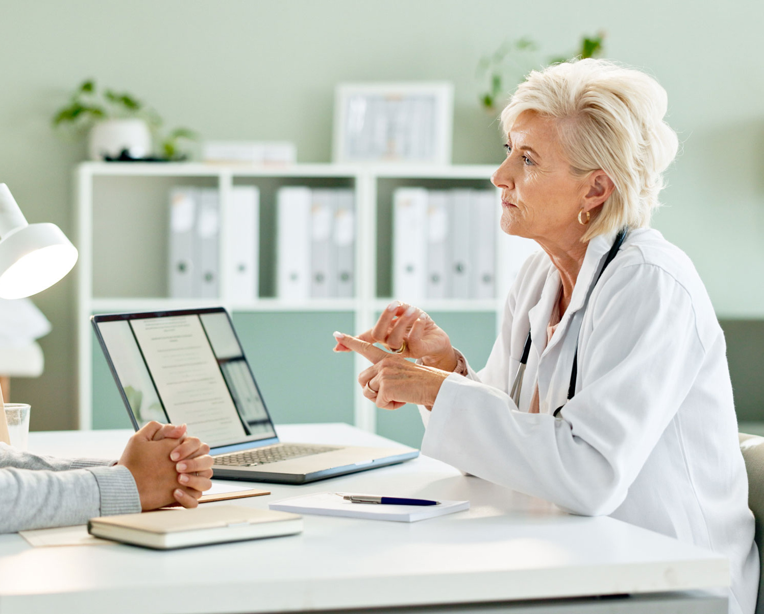 [Translate to English:] Ärztin und Patientin im Gespräch über Onkologie.