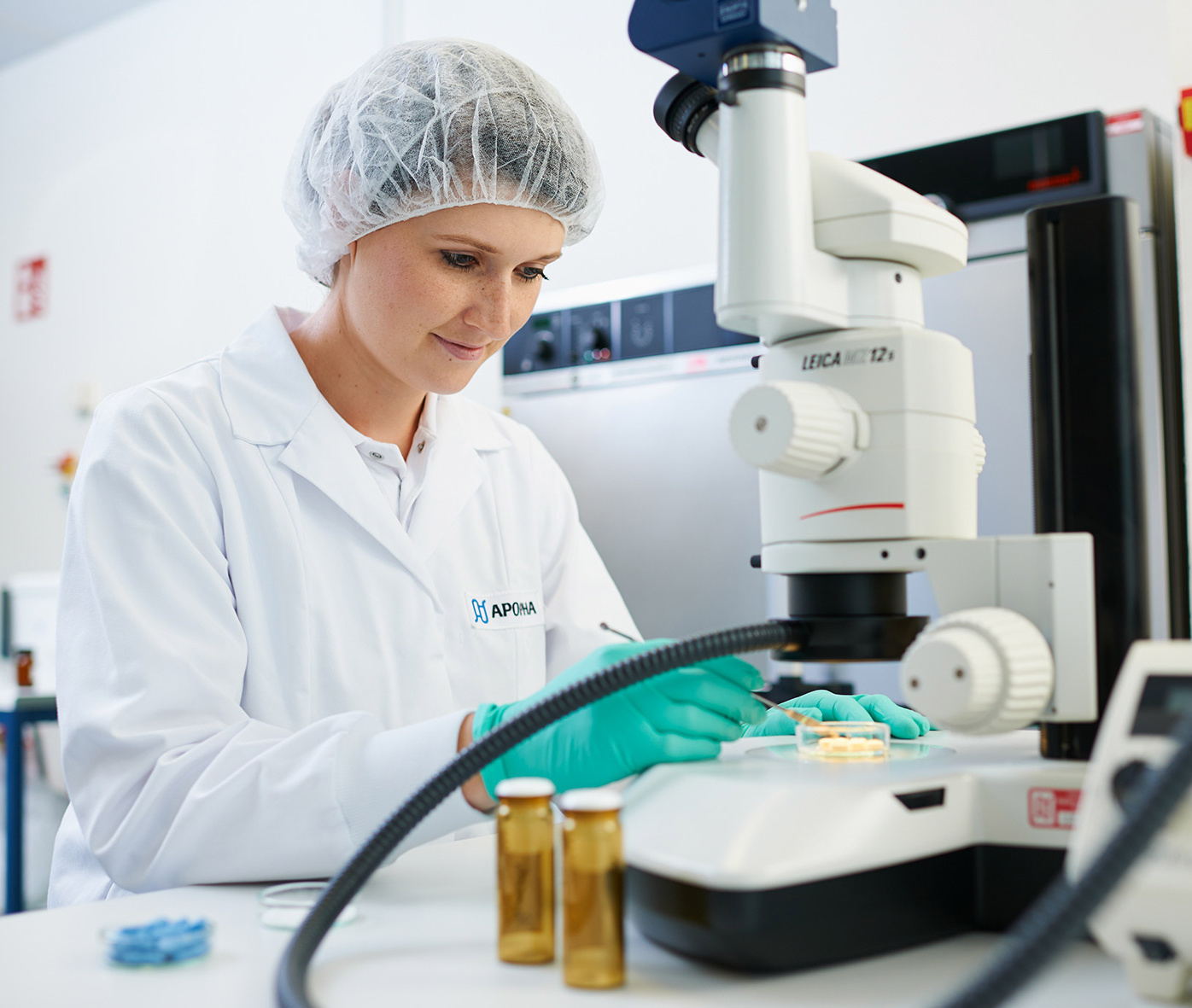 Forscherin vor einem Mikroskop.